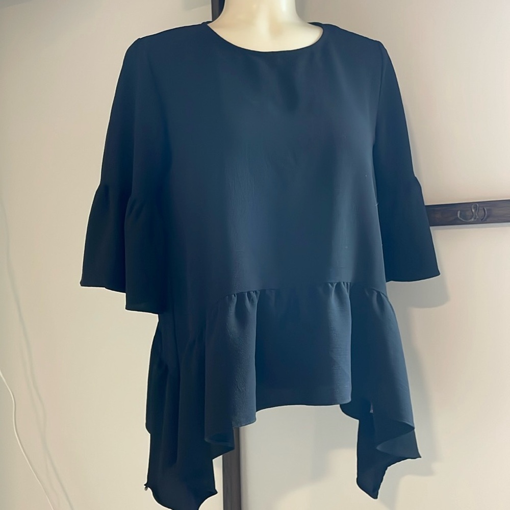 Gibson dressy black top with ruffled sleeve and sharkbite hem.